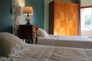 1 dormitorio con 2 camas y una lámpara en un tocador en Gite Liberté-Utah Beach, en Sainte-Marie-du-Mont