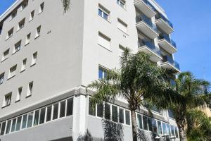 a white building with palm trees in front of it at Casa Ferretti apartment in Brindisi