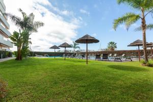 a park with umbrellas and tables and a pool at Marina Vilamoura Aquamar 215 VilamouraSun in Vilamoura