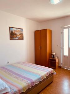 a bedroom with a bed and a wooden cabinet at Djonovic Apartments in Bar