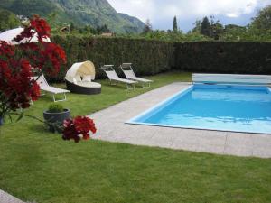 a swimming pool in a yard with lounge chairs at Garni Unterhaslerhof in Merano