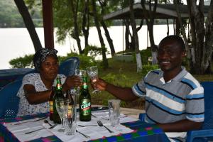 a man and a woman sitting at a table with wine glasses at Raffin Royal Lodge 