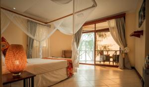 een slaapkamer met een bed en een groot raam bij Sansi Kae Beach Resort in Michamvi