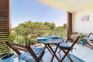a patio with a table and chairs on a balcony at L'étoile du Sud in Saint-Pierre
