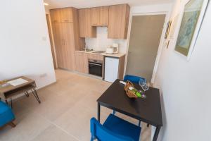 a small kitchen with a table and blue chairs at Chrielka Hotel in Limassol