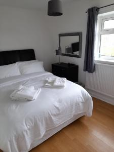 1 cama blanca en un dormitorio con ventana en Quiet 3 bed close to the A1 en Newton Aycliffe