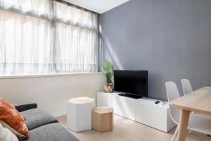 a living room with a couch and a tv on a table at Apartments Sata Sagrada Familia Area in Barcelona