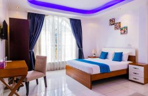 a bedroom with a bed with a desk and a purple ceiling at Villa Asimba in Kigali