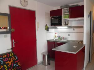 a kitchen with red cabinets and a red door at Appartement Sète, 2 pièces, 4 personnes - FR-1-338-13 in Sète