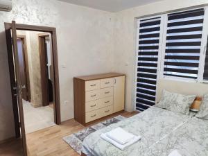 a bedroom with a bed and a dresser and a mirror at Apart Centar in Plovdiv