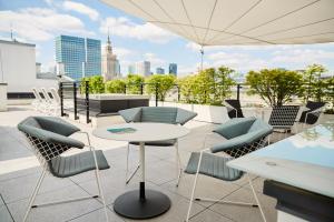a patio with chairs and a table on a roof at No.4 Residence in Warsaw