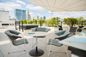 un patio avec des chaises et une table sur le toit dans l'établissement No.4 Residence, à Varsovie