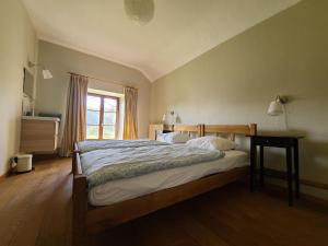 1 dormitorio con cama y ventana en Lovely holiday home in Orval with garden en Florenville