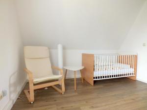 Habitación para bebés con silla y cuna en Family Escape in Lichtenau, en Oberlichtenau
