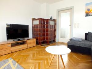 Una sala de estar con un televisor de pantalla plana y una mesa. en Family Escape in Lichtenau, en Oberlichtenau