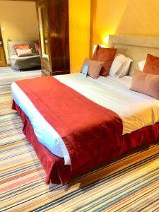 a bedroom with a large bed with a red blanket at Kyriad Saumur Hyper Centre in Saumur
