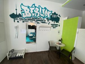 a room with a white wall with graffiti on it at City-Apartment II Kreuzberg in Berlin