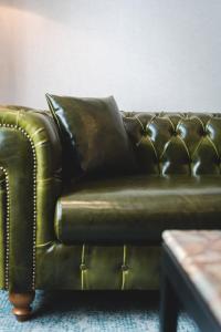 a brown leather couch sitting in a living room at Bristol Hotel Podgorica in Podgorica