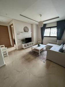a living room with a couch and a table at Lovely Appartement Prestigia Hayriad in Rabat