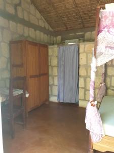 a room with a bed and a desk and a window at Akwaba Chez les Filles in Mahajanga