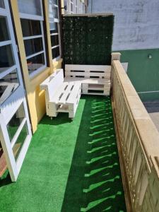 een patio met groen gras en banken op een gebouw bij Ribeira Sacra Apartament in Monforte de Lemos