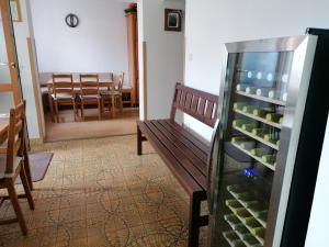 um quarto com um banco e uma mesa com garrafas de vinho em Ubytování Na Špacíru em Mikulov