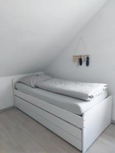 a white bed in a room with a white wall at Sonnige Ferienwohnung bei Familie Köhler in Kappel-Grafenhausen