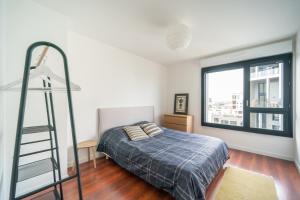 ein Schlafzimmer mit einem Bett, einer Leiter und einem Fenster in der Unterkunft Duplex Asnieres - Duplex en bords de Seine in Asnières-sur-Seine