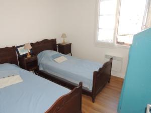 Appartement T3 confortable à Royan, proche plage et commerces - FR-1-71-51 في رويان: غرفة نوم بسريرين ونوافذ