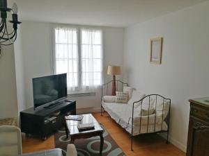 ein Wohnzimmer mit einem Sofa und einem TV in der Unterkunft Appartement Royan, 3 pièces, 5 personnes - FR-1-71-51 in Royan