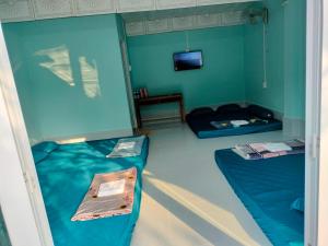 a room with two beds and a tv in it at Nhà nghỉ Ngọc Phượng Hòn Sơn in Lai Sơn