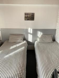 two beds sitting next to each other in a room at Zaton Guesthouse in Cholpon-Ata