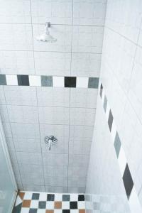 a bathroom with a shower with black and white tiles at Lancaster Guest House in Boksburg
