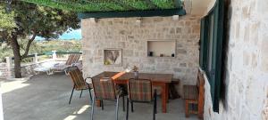 einen Holztisch und Stühle auf einer Terrasse in der Unterkunft Villa Little Hill in Postira