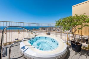 una bañera de hidromasaje en una terraza con la playa al fondo en INTEMPO SKY Apartments 034, en Benidorm