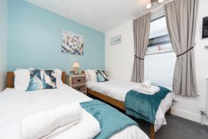 Un dormitorio con dos camas y una ventana. en The Weatherdene, en Great Yarmouth