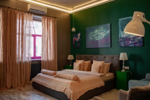 キーウにあるMaNNa Boutique Hotelの緑の壁のベッドルーム1室(大型ベッド1台付)