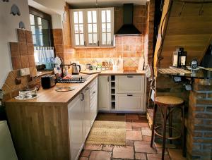 a kitchen with white appliances and a brick wall at Leśna Strzecha Domek in Rotembark