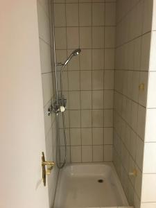 uma banheira com uma cabeça de chuveiro na casa de banho em Simple Studio in the Center of Burgdorf - 36 m2 with prívate parking em Burgdorf