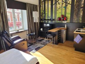 Cette chambre comprend un bureau, une chaise et une table. dans l'établissement Stay Apartment Hotel, à Karlskrona