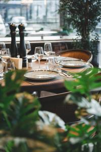 a wooden table with glasses and plates on it at Bristol Hotel Podgorica in Podgorica