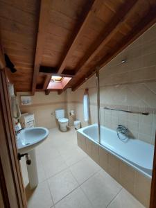 a bathroom with a tub and a toilet and a sink at Hotel Rural El Angel de la Guarda in Güemes