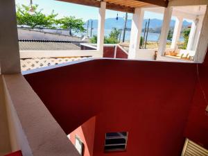 una vista desde la parte superior de una casa con una pared roja en Pousada Aconchego Recanto Canto Do Mar en Bairro da Enseada