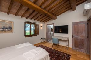 Dormitorio con cama, escritorio y TV en Fattoria Colsanto, en Torre del Colle