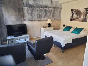 Stay Apartment Hotel في كارلسكرونا: غرفة نوم بسرير وتلفزيون بشاشة مسطحة