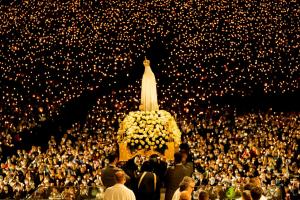 a large crowd of people standing around a statue at Ribeiro Hotel in Fátima