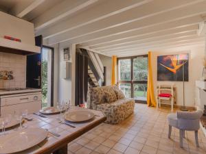 a kitchen and living room with a table and a chair at Holiday Home Le Clos du Golf-2 by Interhome in Cabourg