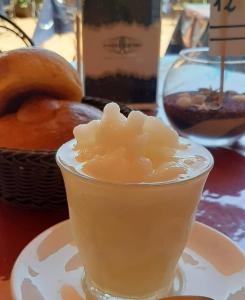 a drink in a glass on a table with a basket of donuts at Torrevarata vacanze in Santa Teresa di Riva