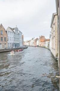 Un gruppo di persone su una barca su un fiume di Canalview Hotel Ter Reien a Bruges