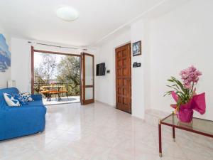 a living room with a blue couch and a table at Holiday Home Candy by Interhome in Nerano